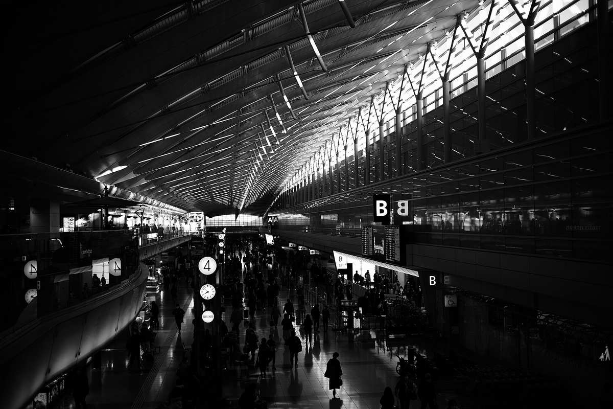 Silhouetten von Reisenden in der Abflughalle des Flughafens Haneda im Morgenlicht